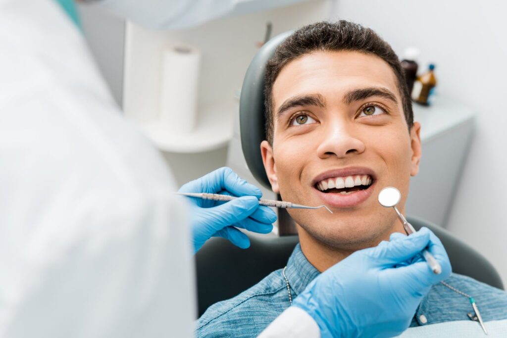 A man seated in a dental chair for his dental exam.